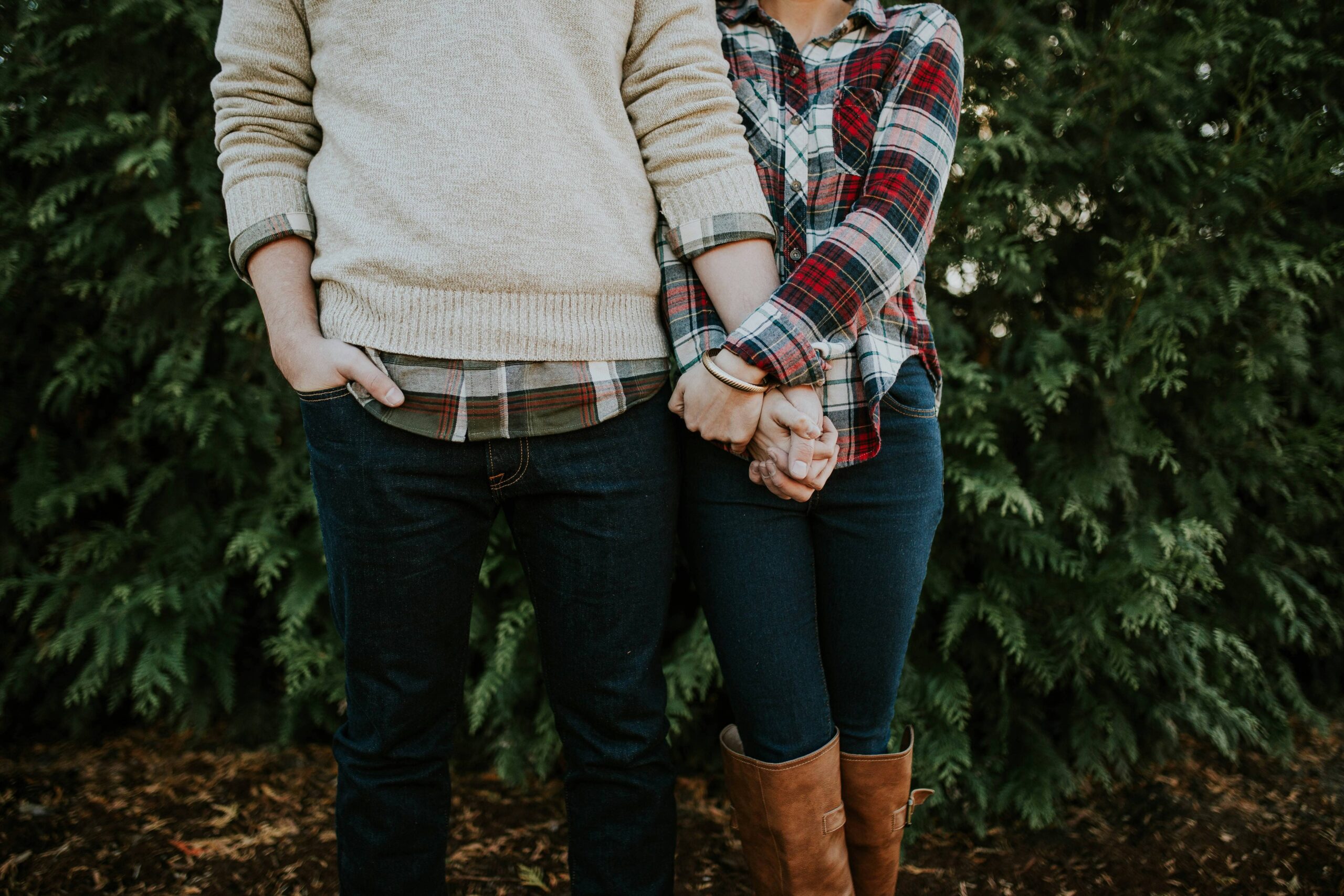 couple in plaid holding hands offering support to stay sober during the holidays