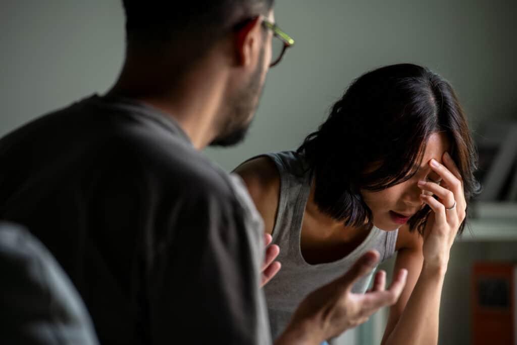 Young Asian married couple after a fight, Angry couple ignoring each other, relationship troubles due to one partner's sex addiction.