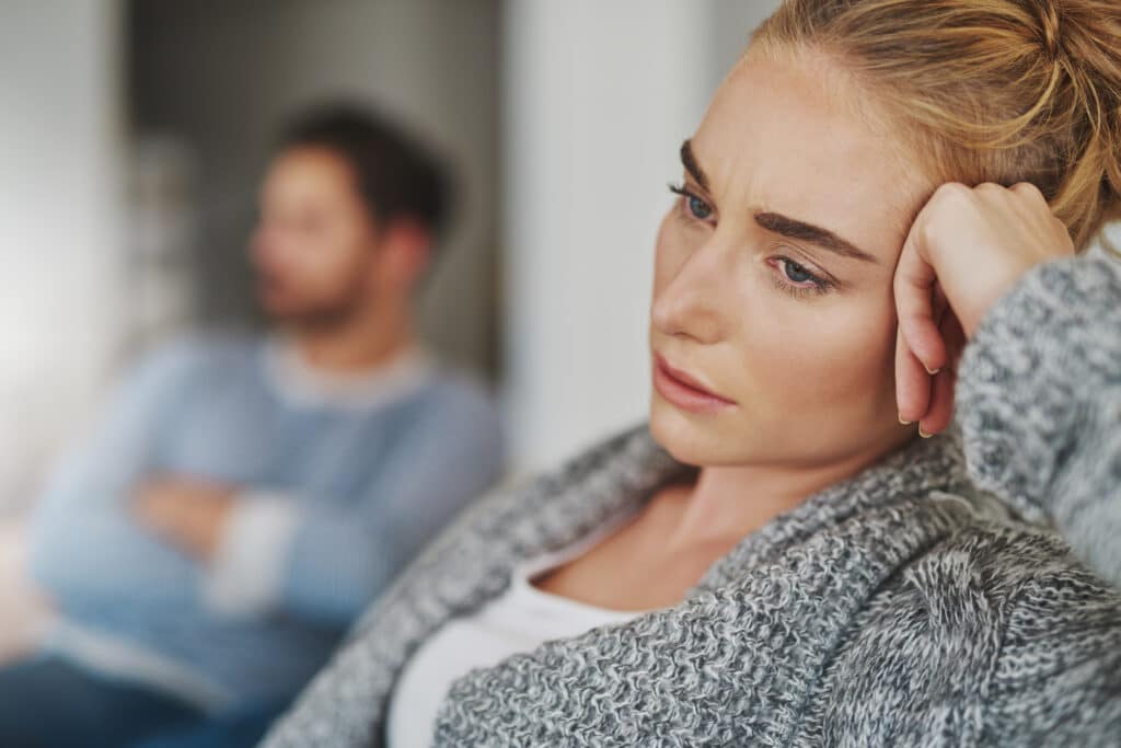 Cropped shot of an unhappy young couple after a fight at home as partner of sex addict struggles to heal