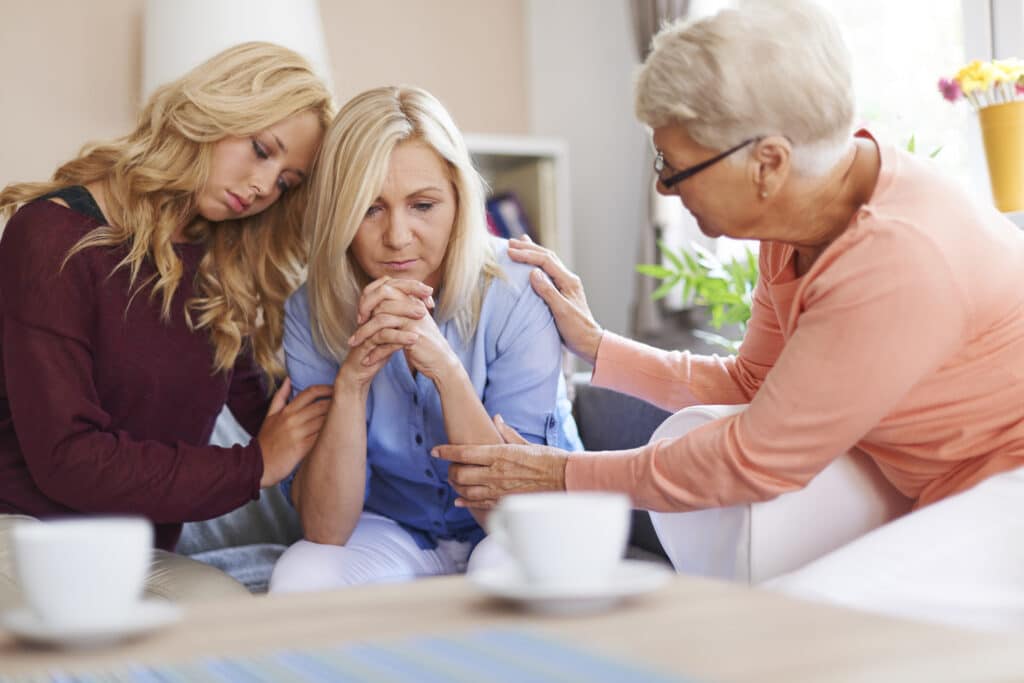 daughter and grandmother supporting mother through addiction in family therapy