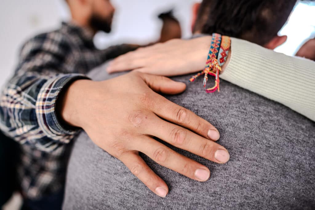 A comforting gesture between patients during a group therapy session