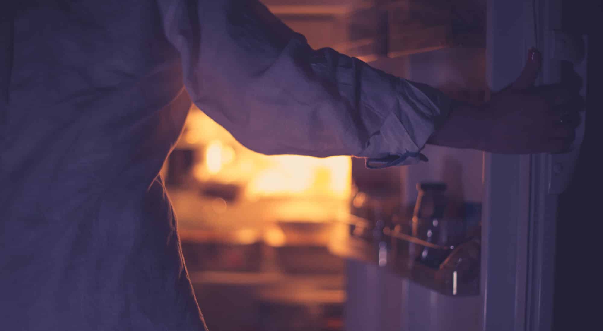 woman looking into fridge of food