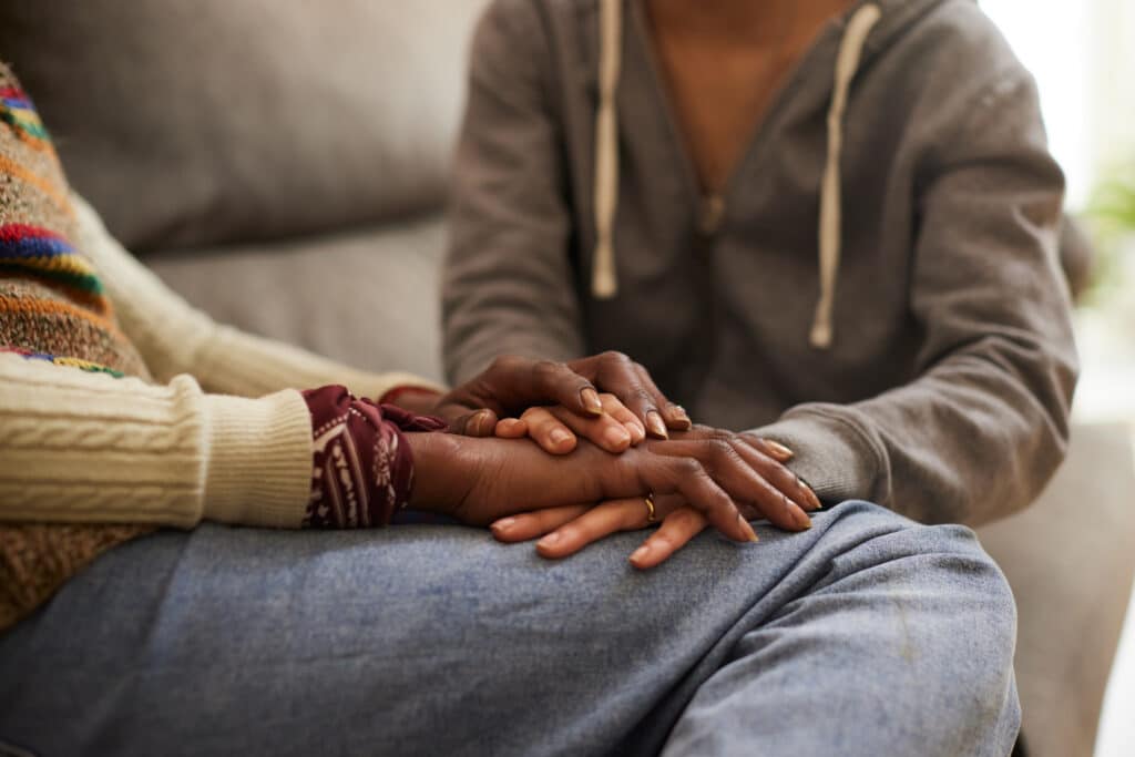 woman holding hands with loved one who is giving her support to heal from complex trauma