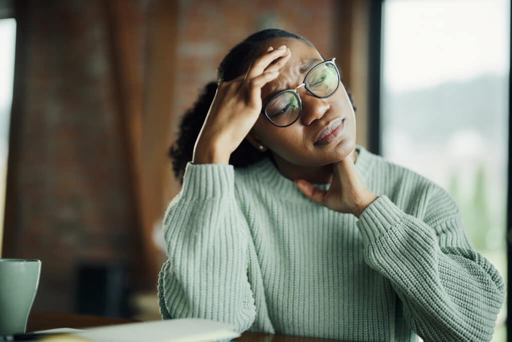 woman with hand on her head stressed and struggling to regulate her emotions